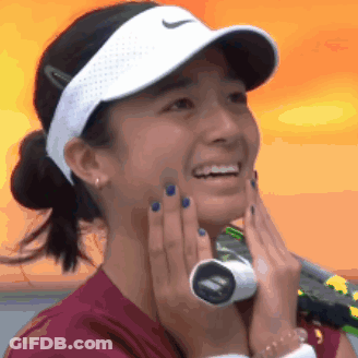 A Woman Wearing A Nike Hat Is Smiling And Holding A Tennis Racket GIF