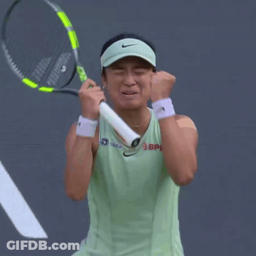 A Woman Wearing A Nike Visor Is Holding A Tennis Racquet In Her Hands GIF