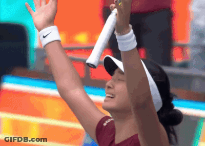 A Woman Wearing A Nike Wristband Is Holding A Tennis Racquet In Her Hand GIF
