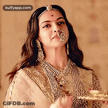 A Woman Wearing A Nose Ring Is Holding A Tray Of Food . GIF