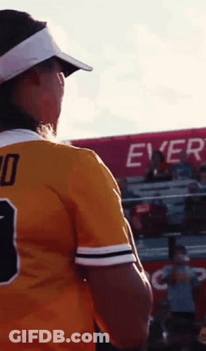 A Woman Wearing A Number 10 Jersey Stands In Front Of A Crowd GIF