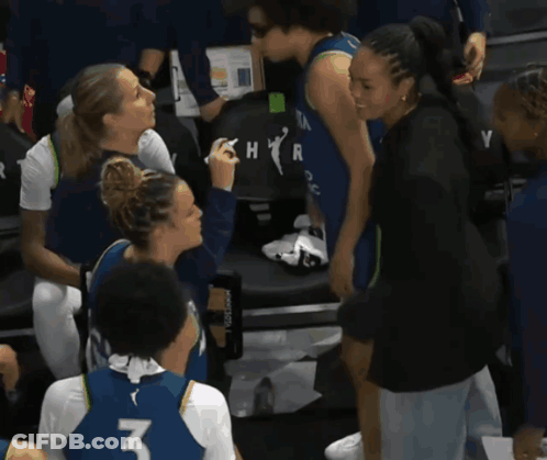 A Woman Wearing A Number 3 Jersey Talks To Another Woman GIF