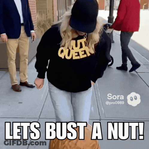 A Woman Wearing A Nut Queen Sweatshirt Is Holding A Nut GIF