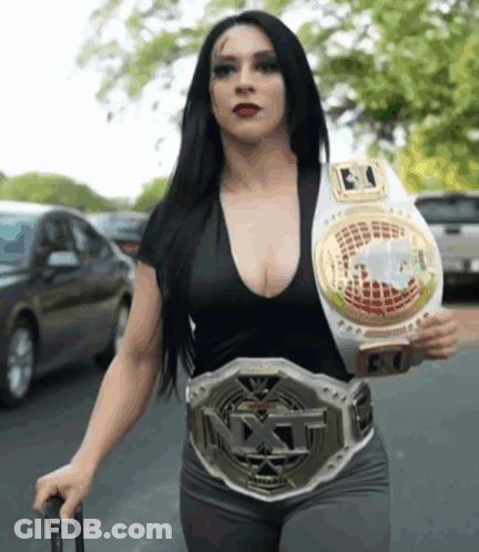 A Woman Wearing A Nxt Belt Is Walking Down A Street GIF