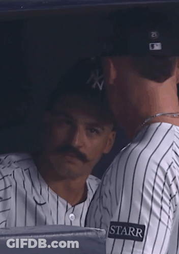 A Woman Wearing A Ny Hat Looks At Something In The Distance GIF