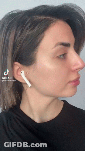 A Woman Wearing A Pair Of White Ear Buds Has A Tiktok Icon On Her Face GIF