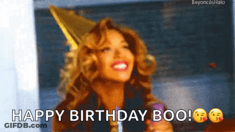 A Woman Wearing A Party Hat Is Smiling And Holding A Lollipop . GIF