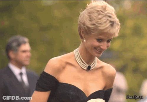 A Woman Wearing A Pearl Necklace And A Black Dress With The Name Rosalyn51 On The Bottom GIF