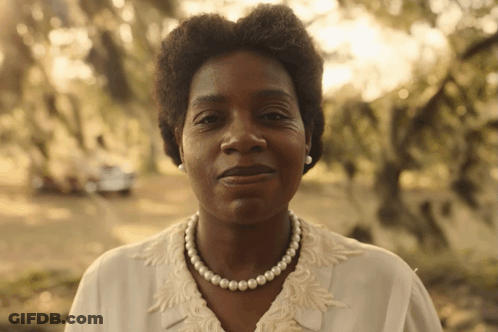 A Woman Wearing A Pearl Necklace And Pearl Earrings GIF