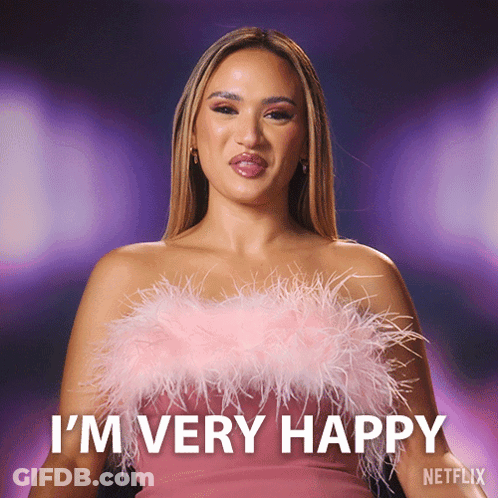 A Woman Wearing A Pink Feathered Top Says I 'M Very Happy GIF