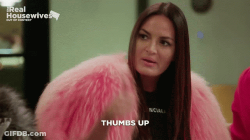 A Woman Wearing A Pink Fur Coat And A Black Balenciaga Shirt Says Thumbs Up GIF