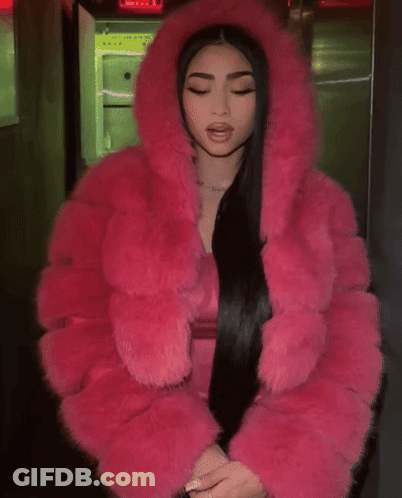 A Woman Wearing A Pink Fur Coat With A Hood GIF