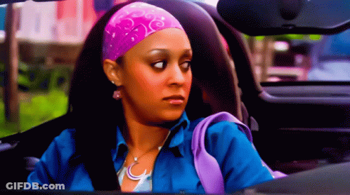 A Woman Wearing A Pink Headband And A Blue Shirt Is Driving A Car GIF