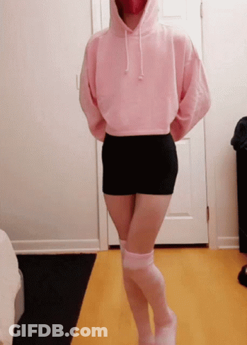 A Woman Wearing A Pink Hoodie And Black Shorts GIF