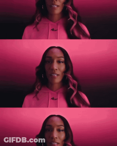 A Woman Wearing A Pink Hoodie With The Nike Logo On The Front GIF