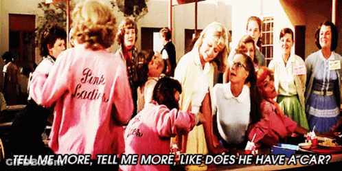 A Woman Wearing A Pink Jacket That Says Pink Ladies Stands In Front Of A Group Of Women GIF