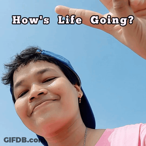 A Woman Wearing A Pink Shirt And A Blue Hat Is Smiling With The Words How 'S Life Going Written Above Her GIF