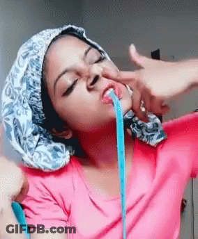 A Woman Wearing A Pink Shirt And A Blue Hat Is Vomiting Blue Liquid GIF