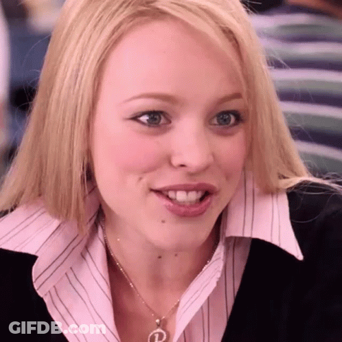 A Woman Wearing A Pink Shirt And A Necklace With The Letter P On It GIF