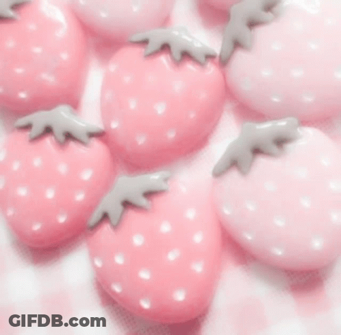 A Woman Wearing A Pink Sweater And A Butterfly Necklace GIF