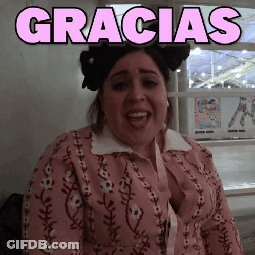 A Woman Wearing A Pink Sweater With The Word Gracias Above Her GIF