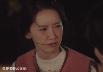 A Woman Wearing A Pink Vest And A Headset Looks At The Camera GIF