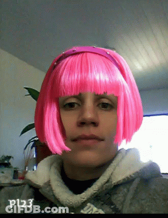 A Woman Wearing A Pink Wig Has The Letters P123 On The Bottom Right GIF