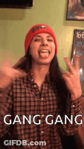A Woman Wearing A Plaid Shirt And A Red Hat Is Making A Funny Face With The Words Gang Gang Written Below Her GIF