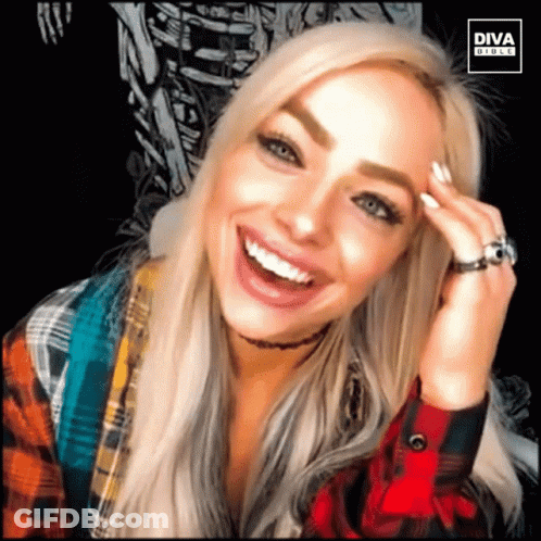 A Woman Wearing A Plaid Shirt And A Ring Is Smiling For A Diva Photo GIF