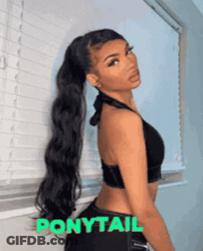 A Woman Wearing A Ponytail Stands In Front Of A Window GIF