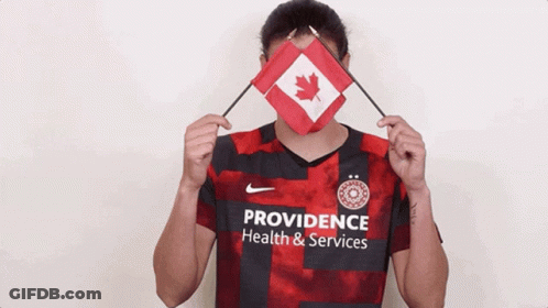 A Woman Wearing A Providence Health And Services Jersey Holds A Canadian Flag GIF