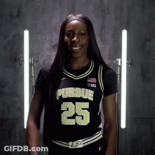 A Woman Wearing A Purdue Jersey Number 25 Smiles For The Camera GIF