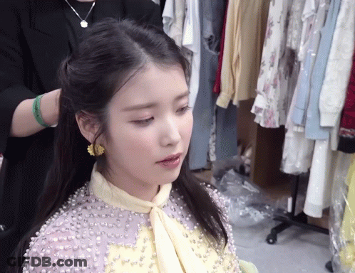 A Woman Wearing A Purple Dress With Pearls On It GIF