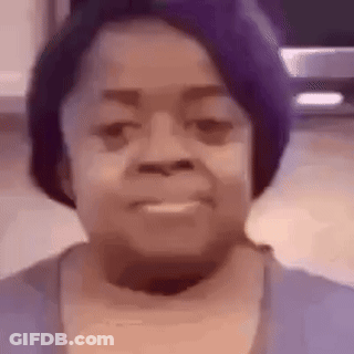A Woman Wearing A Purple Hat Is Smiling And Looking At The Camera . GIF