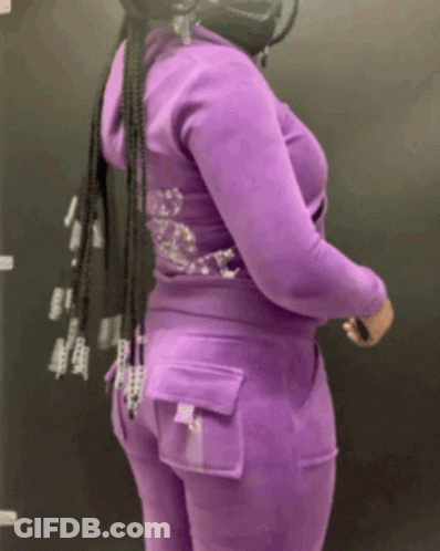 A Woman Wearing A Purple Hoodie And Pants With Rhinestones On The Back GIF