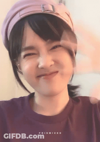 Woman In Purple Shirt And Pink Hat With Prismized Text GIF