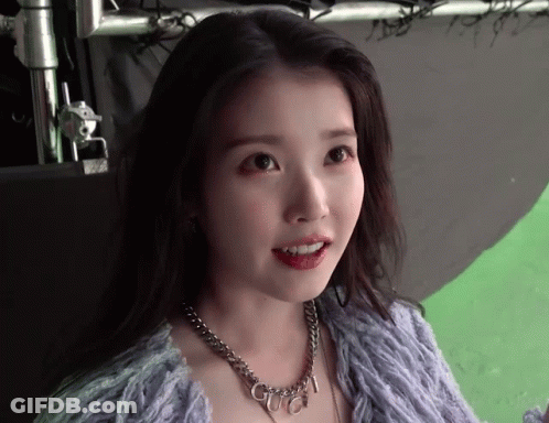 A Woman Wearing A Purple Sweater And A Necklace With The Word Gucci On It GIF