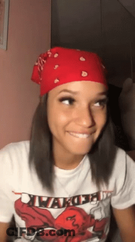 A Woman Wearing A Red Bandana And A White T-Shirt Is Smiling And Looking Up . GIF