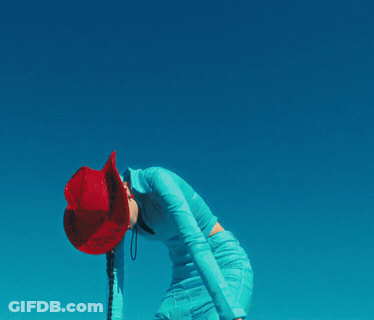 A Woman Wearing A Red Cowboy Hat And A Blue Dress GIF