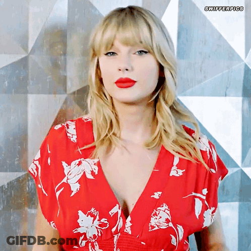 A Woman Wearing A Red Floral Dress With Swifterpics Written On The Bottom Right GIF