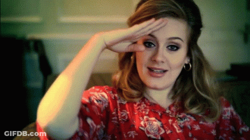 A Woman Wearing A Red Floral Shirt Is Making A Funny Face GIF