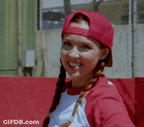 A Woman Wearing A Red Hat And A White Shirt Smiles At The Camera GIF