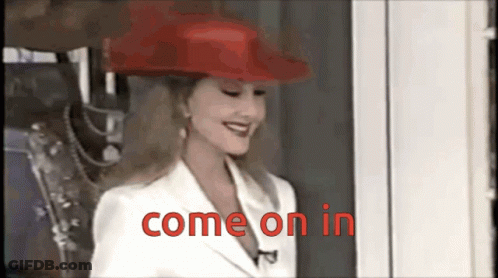 A Woman Wearing A Red Hat And White Jacket Says Come On In GIF