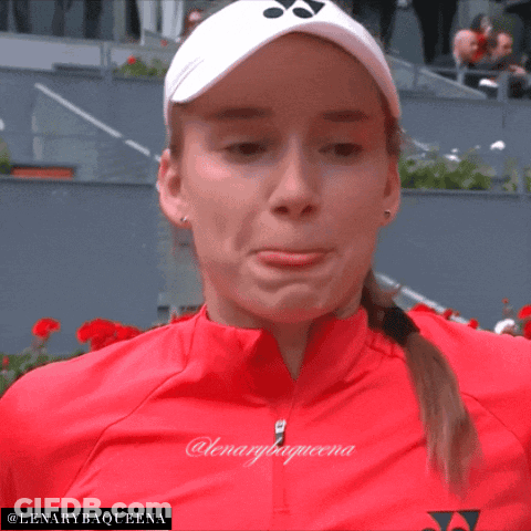 A Woman Wearing A Red Jacket And A White Yonex Hat With The Name Lenarybaqueena On The Bottom GIF