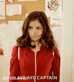 A Woman Wearing A Red Jacket Is Standing In Front Of A Bulletin Board . GIF