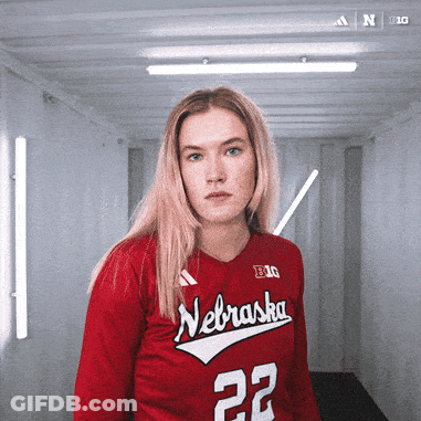 A Woman Wearing A Red Nebraska Jersey With The Number 22 GIF