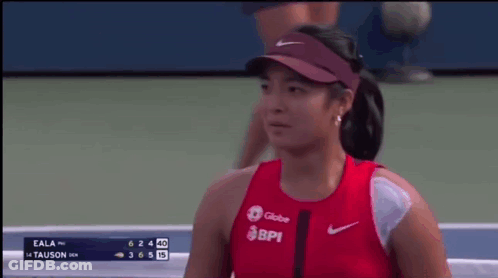 A Woman Wearing A Red Shirt That Says Bpi Is Smiling On A Tennis Court GIF