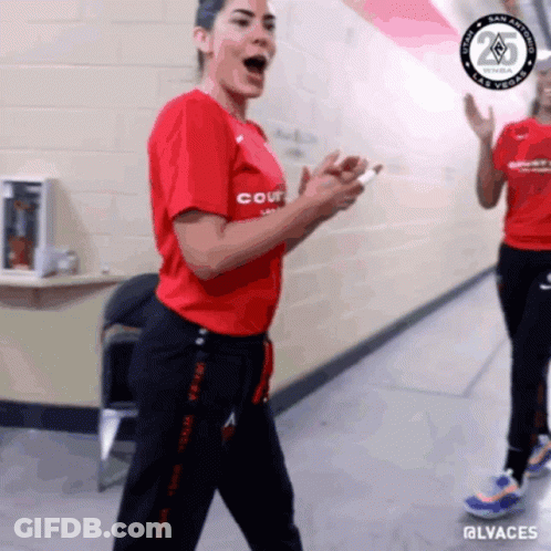 A Woman Wearing A Red Shirt That Says Court Is Standing In A Hallway GIF