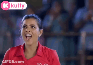 A Woman Wearing A Red Shirt With The Number 03 On It Is Smiling GIF