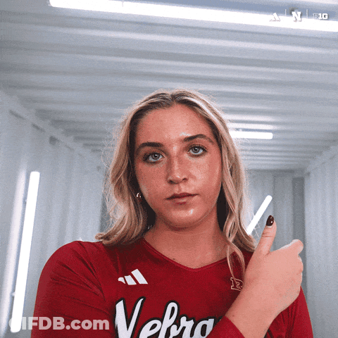 A Woman Wearing A Red Shirt With Velbro On It GIF